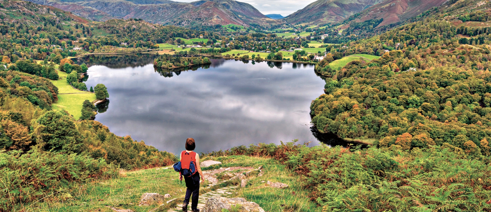 Rearview of a woman standing on mountain against the lake