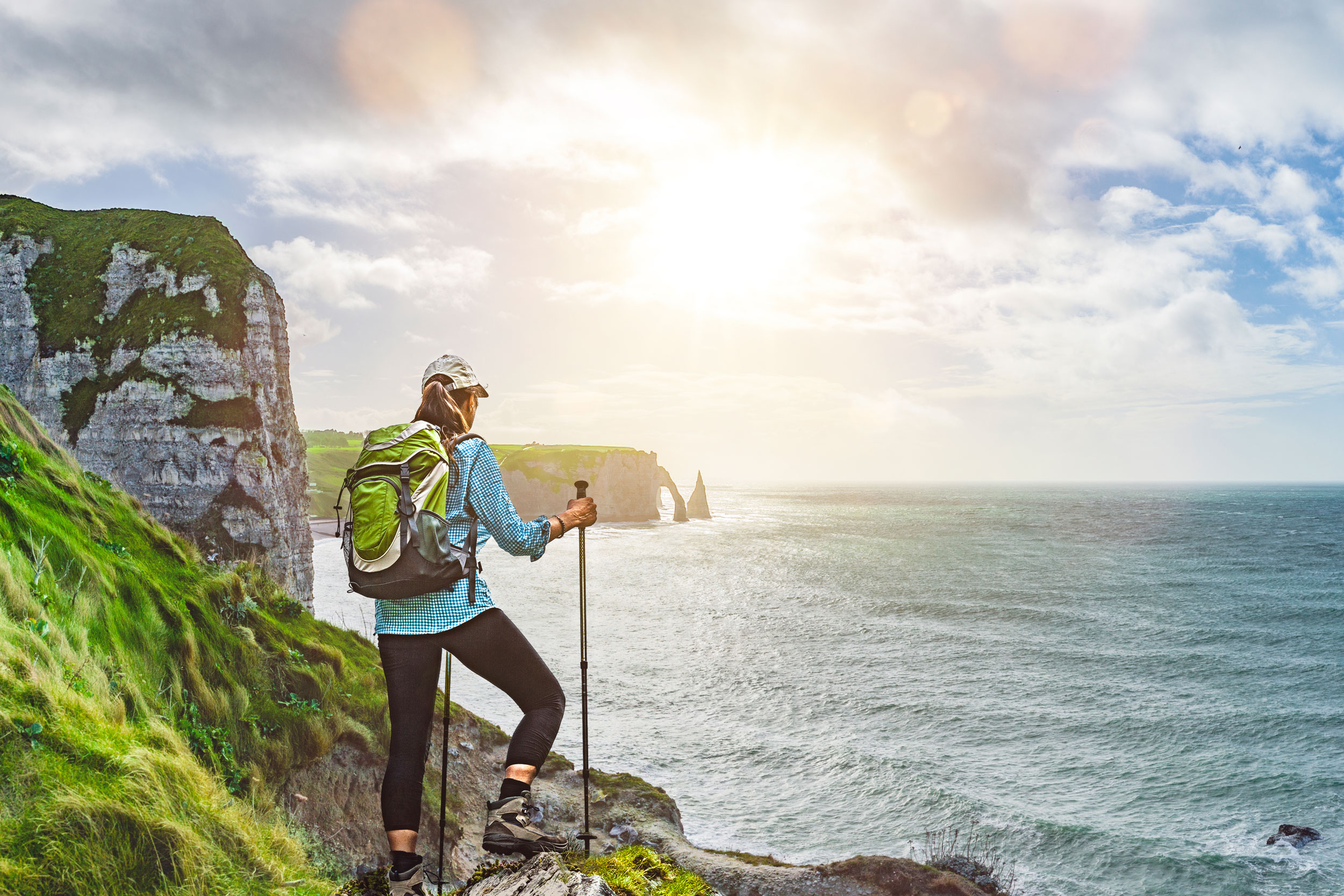 Hiker at the coast line enjoying the view of the sunset and sea